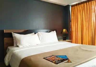 a bedroom with a large bed with a book on it at Studio Sea View Patong in Patong Beach