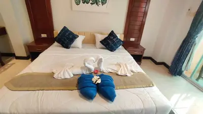 a bedroom with a bed with towels on it at PHADEE APARTMENT in Karon Beach