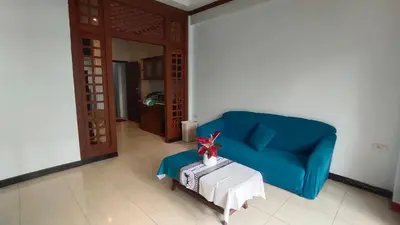 a living room with a blue couch and a table at PHADEE APARTMENT in Karon Beach