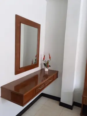 a dressing table with a mirror on a wall at PHADEE APARTMENT in Karon Beach