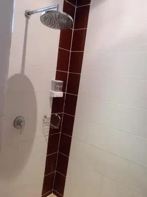 a shower with a shower head in a bathroom at PHADEE APARTMENT in Karon Beach