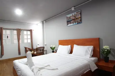 a bedroom with a large bed with white sheets at Aladdin Guest House in Phi Phi Don