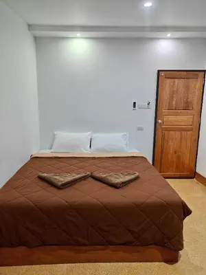 a bed in a room with two towels on it at Aladdin Guest House in Phi Phi Don