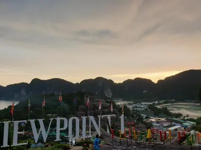 a view of a sign with mountains in the background at Aladdin Guest House in Phi Phi Don