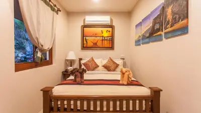 a bedroom with a bed with a stuffed elephant on it at Saifon Villas - Luxurious Pool Villas in Ao Nang Beach