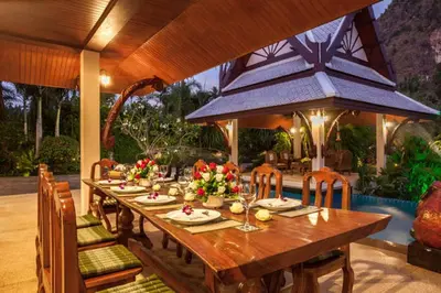 a wooden table with chairs and a dining room at Saifon Villas - Luxurious Pool Villas in Ao Nang Beach