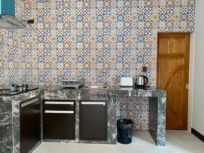 a kitchen with a counter and a wall at Blue Aura Pool Villa in Nai Yang Beach
