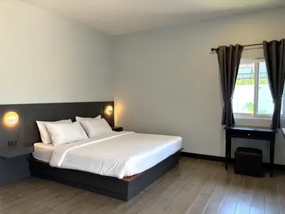 a bedroom with a large bed and a window at Blue Aura Pool Villa in Nai Yang Beach