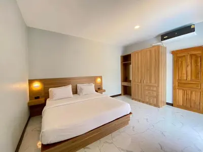 a bedroom with a white bed and a wooden cabinet at Blue Aura Pool Villa in Nai Yang Beach