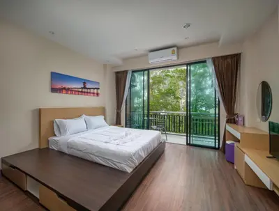 a bedroom with a bed and a balcony at Naithon Beachfront Condotel in Nai Thon Beach
