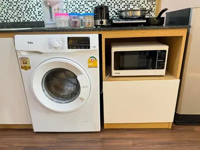 a washing machine and a microwave in a kitchen at Naithon Beachfront Condotel in Nai Thon Beach