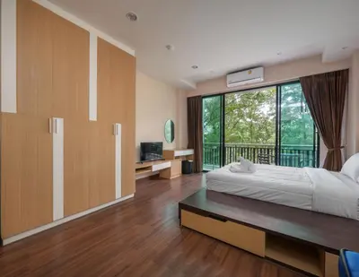 a bedroom with a bed and a large window at Naithon Beachfront Condotel in Nai Thon Beach