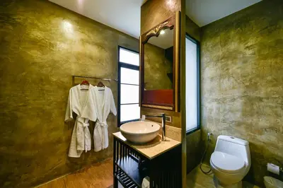 a bathroom with a sink and a toilet at Coco Paradiso Phuket SHA in Phuket Town