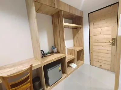 a room with a tv and a wooden wall at Yuwadee Resort in Chalong