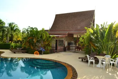 a swimming pool in front of a house at Yuwadee Resort in Chalong