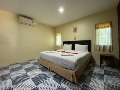 a bedroom with a large bed in a room at Yuwadee Resort in Chalong