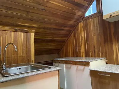 a kitchen with a sink and wooden walls at Yuwadee Resort in Chalong