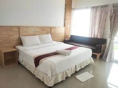 a bedroom with a large bed and a window at Yuwadee Resort in Chalong