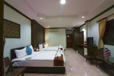 a hotel room with a bed and a television at Baan Veerakit Hotel in Patong Beach