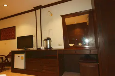 a room with a desk with a television and a mirror at Baan Veerakit Hotel in Patong Beach