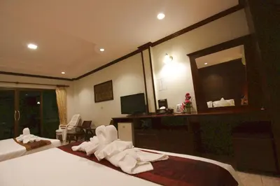 a hotel room with two beds and a large mirror at Baan Veerakit Hotel in Patong Beach
