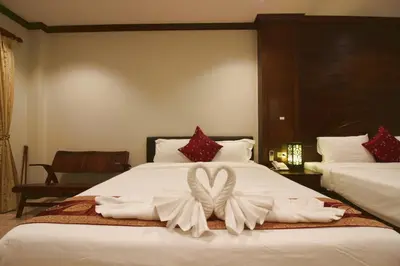 a hotel room with a bed with a bow on it at Baan Veerakit Hotel in Patong Beach