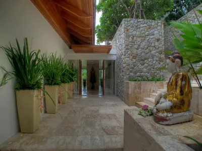 a hallway with plants and a statue in a building at Villa Minh in Kamala Beach
