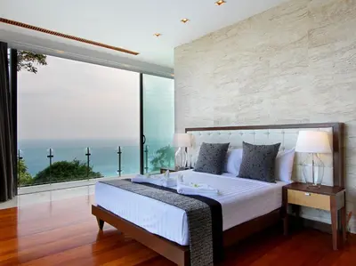 a bedroom with a large bed with a large window at Villa Minh in Kamala Beach
