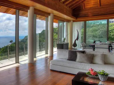 a living room with a white couch and large windows at Villa Minh in Kamala Beach