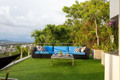 a patio with a blue couch on the grass at Villa Beyond 9 Bedrooms Seaview - Full Services in Bang Tao Beach