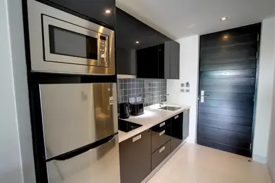 a kitchen with a stainless steel refrigerator and a sink at Lets Phuket Twin Sands Resort & Spa in Patong Beach
