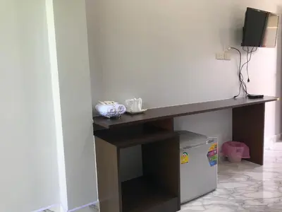 a desk in a room with a television on it at G-HAN Residence in Nai Yang Beach