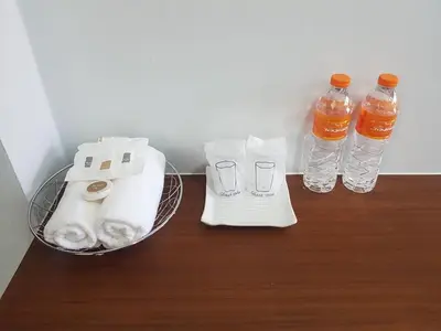 a table with two bottles of water and towels at G-HAN Residence in Nai Yang Beach