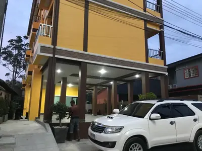 a white suv parked in front of a building at G-HAN Residence in Nai Yang Beach