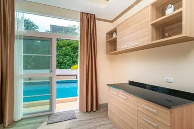 a kitchen with a large window and a pool at Phuket9 Residence in Chalong
