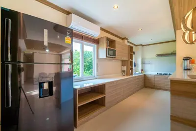 a kitchen with a refrigerator and a window at Phuket9 Residence in Chalong
