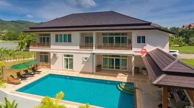 a house with a swimming pool in front of it at Phuket9 Residence in Chalong