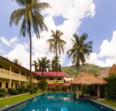 a view of the resort with a swimming pool and palm trees at Austrian Garden Hotel & Restaurant Patong in Patong Beach