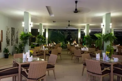 a dining room with tables and chairs and tablesktop at Austrian Garden Hotel & Restaurant Patong in Patong Beach