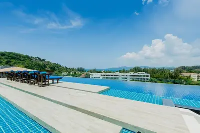 a swimming pool with tables and chairs on a building at Unique loft 2-BR near of Surin Beach, private patio in Surin Beach