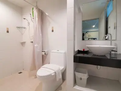 a white bathroom with a toilet and a sink at Phupara Place SHA Certified in Phuket Town