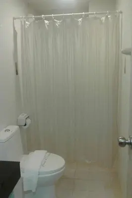 a bathroom with a white shower curtain and a toilet at Phupara Place SHA Certified in Phuket Town