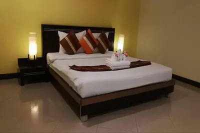 a bedroom with a large bed with two lamps at Phupara Place SHA Certified in Phuket Town