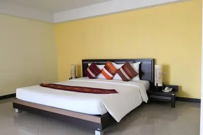 a bedroom with a large white bed with red pillows at Phupara Place SHA Certified in Phuket Town
