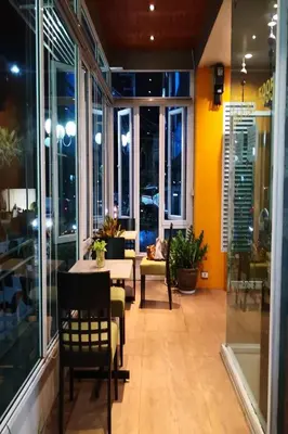 a dining room with a table and chairs and windows at Phupara Place SHA Certified in Phuket Town