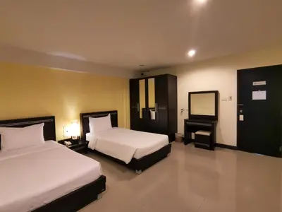 a hotel room with two beds and a mirror at Phupara Place SHA Certified in Phuket Town