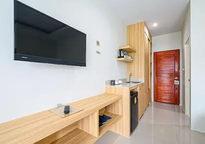 a living room with a large flat screen tv on a wall at The Beach at Klong Muang in Klong Muang Beach