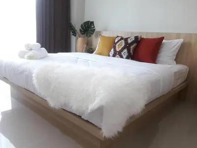 a white bed with many pillows and a white blanket at The Beach at Klong Muang in Klong Muang Beach