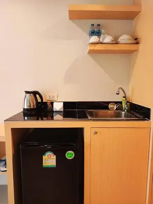 a small kitchen with a sink and a black refrigerator at The Beach at Klong Muang in Klong Muang Beach