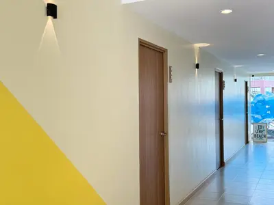 a hallway with a door and a room with a floor at Fishtail Hostel Phuket in Karon Beach